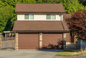 Garage door in luxury house with trees and nice landscape in Summer in Vancouver, Canada, North America. Day time on August 2025.
