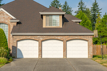 Garage door in luxury house with trees and nice landscape in Summer in Vancouver, Canada, North America. Day time on August 2025.