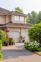 Garage door in luxury house with trees and nice landscape in Summer in Vancouver, Canada, North America. Day time on August 2025.