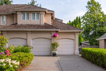 Garage door in luxury house with trees and nice landscape in Summer in Vancouver, Canada, North America. Day time on August 2025.