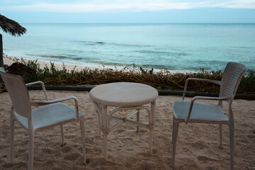 Inviting beach setup with tables and chairs create a relaxed atmosphere.