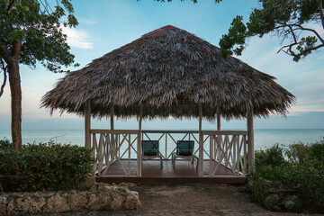 Panoramic view of a cabana facing the ocean under a bright sky.