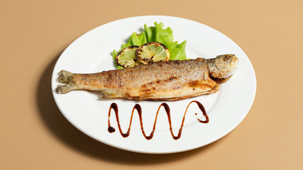 Roasted fish with lemon on plate
