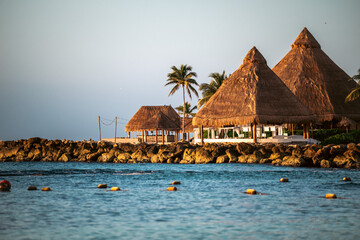 Charming beach huts by tranquil water, perfect for a relaxing getaway.