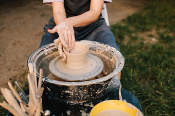 Clay molding on the wheel highlights pottery artistry and skill. Potter shaping clay bowl on a wheel. Clay spins gently under hands as potter forms bowl.