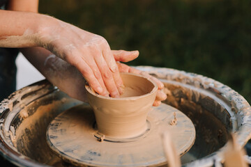 Clay molding on the wheel highlights pottery artistry and skill. Potter shaping clay bowl on a wheel. Clay spins gently under hands as potter forms bowl.