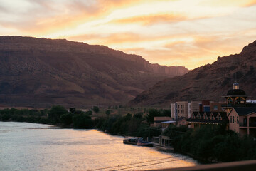 Majestic sunset reflecting on calm waters with mountains in the background.