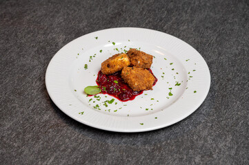 Crispy Fried Camembert Cheese with Sweet Cranberry Sauce on White Plate. Gourmet Appetizer Dish