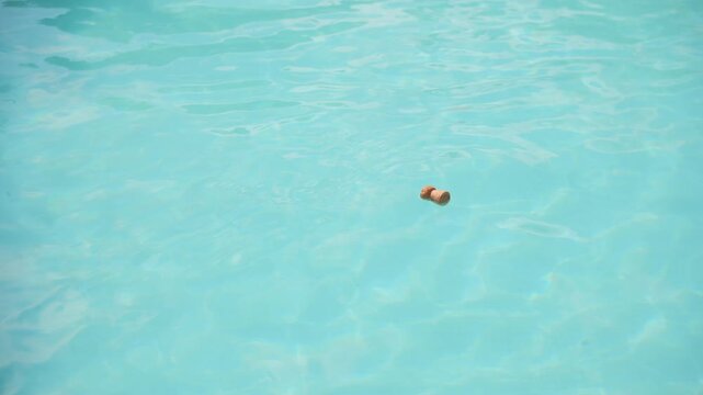 Champagne cork floating in a pool