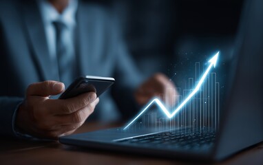 Businessman Using Phone with Financial Growth Graph on Laptop