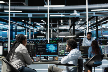 Developer with paraplegia and manager inspect neural network data center used for machine learning. Inclusive workplace worker and supervisor optimize server hub for artificial intelligence workloads