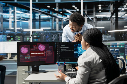 IT staff members in high tech facility trying to protect servers from hacker attack stealing sensitive information. Data center cybersecurity division coworkers protecting rigs during security breach