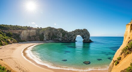Coastal arch formation with beach and turquoise water under a clear sky.