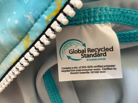 Polyester сlothing label with the Global Recycled Standard (GRS) certification tag, recycled polyester. Sustainable fashion practices and eco-friendly textile production concept