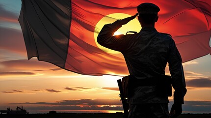 Silhouette of a soldier saluting at sunset