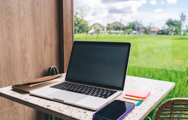 Fototapeta premium Young woman in orange activewear checks smartwatch on beach, symbolizing integration of wearable tech in personal fitness and digital health awareness.