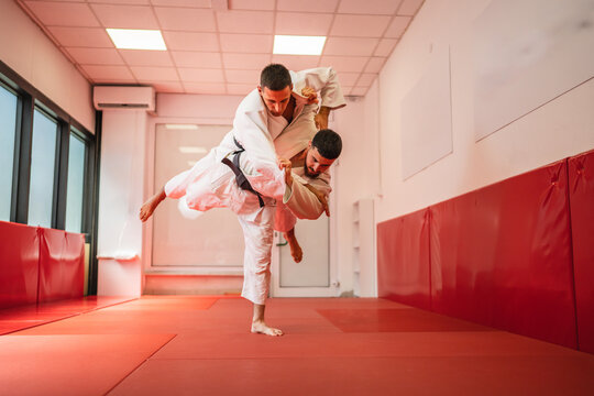 Judo athletes performing shoulder throw technique during training - Powered by Adobe