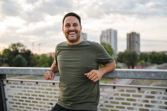 Happy man smiling on city bridge portrait