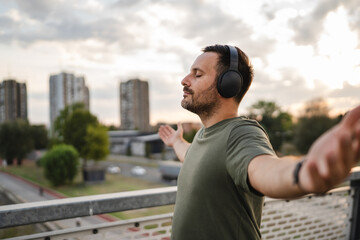 Man enjoying music with headphones feeling freedom outdoors