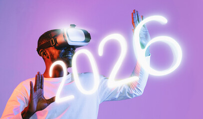 A mature African American man wearing virtual reality glasses is reaching out with his hands, trying to touch virtual objects. The colorful neon background enhances the immersive experience.