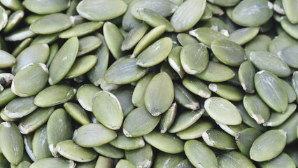 A pile of green peeled pumpkin seeds as a textured solid background for a banner template page design