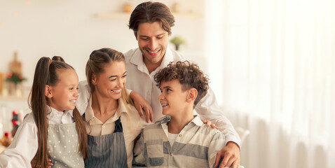 Portrait of loving parents and children posing together in kitchen, cooking tasty meal for family Christmas celebration, preparing roasted turkey for festive dinner at home. Holiday fun concept