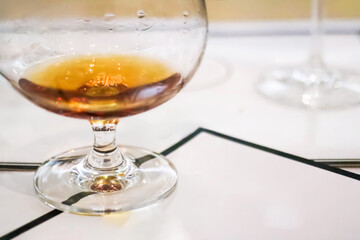 Cognac or rum in snifter glass on white table