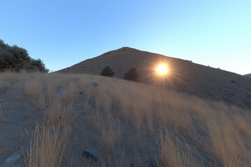 Sunrise over a dry, hilly landscape