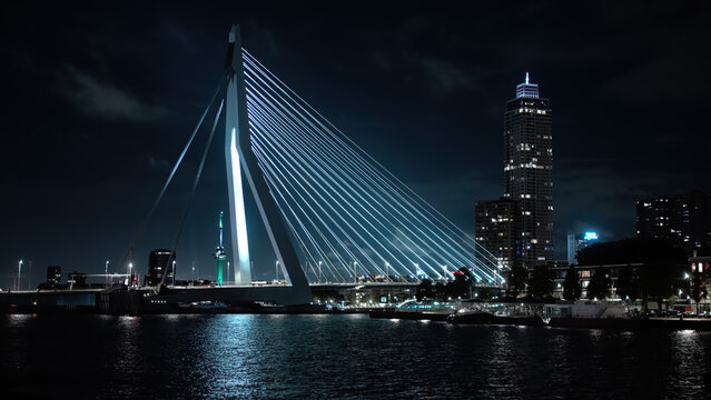 ROTTERDAM, NETHERLANDS - SEPTEMBER 13, 2025 - Erasmusbrug bridge standing tall, spanning the river, showcasing Rotterdam s illuminated cityscape