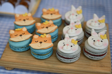 macarons on a wooden table, cute fox and rabbit macarons, sweet animal-shaped desserts, colorful macarons for kids party, tasty and creative sweets, fondant rabbits and foxes


