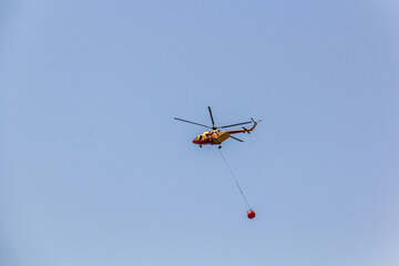 Firefighting helicopter above Ancient Olympia on Peloponnese peninsula, Greece