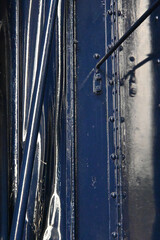Close-up Detail of Dark Blue Metal Surface with Stripes and Hardware Closeup of Blue Train Car Details