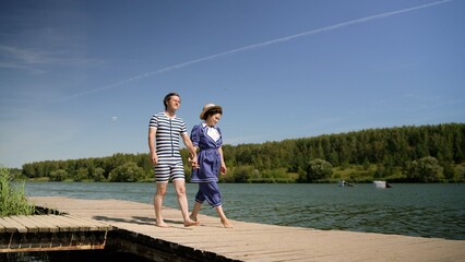 Couple walking on dock wearing retro swimsuits