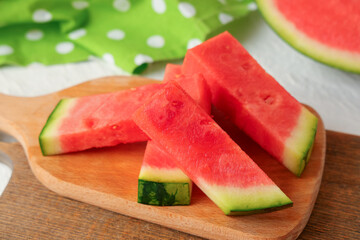 Wooden board with pieces of sweet watermelon on white background, closeup
