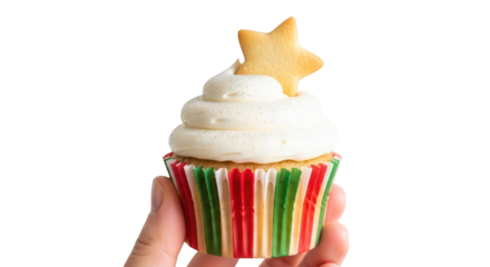 A hand holding a festive christmas cupcake with white frosting and a star cookie on top, isolated on transparent background