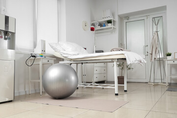 Interior of hospital ward with bed, door and clothes rack