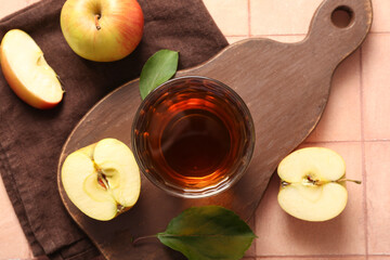 Glass of fresh apple juice on beige tile background