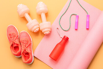 Sneakers and sports equipment on orange background