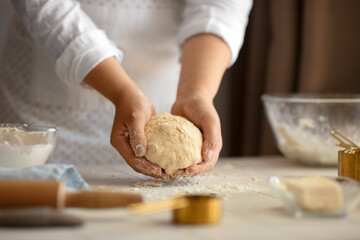 Woman preparing traditional cinnamon rolls in kitchen