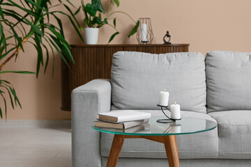 Interior of modern living room with sofa, coffee table and burning candles