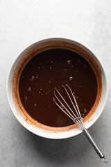 Overhead view of dark chocolate mud cake batter in a mixing bowl, process of making chocolate mud cake, making a dark chocolate cake