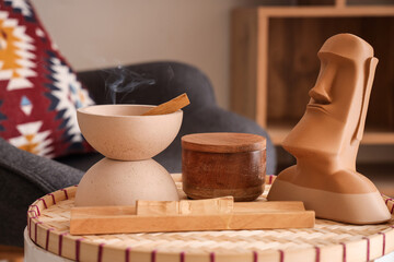Bowl with Palo Santo and statue on table in living room, closeup