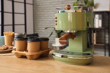 Coffee machine with cups on counter in office, closeup