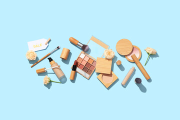 Composition with different decorative cosmetics, sale tag and flowers on color background