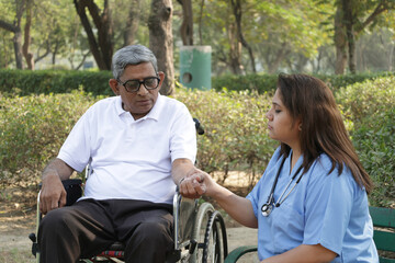 Fototapeta premium Indian doctor nurse caring senior citizen patient in garden. she caring all the time at outdoors