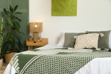 Comfortable bed with bedside table in interior of bedroom