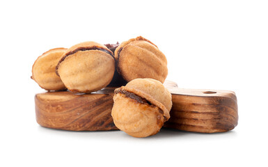 Wooden board of sweet walnut shaped cookies with boiled condensed milk on white background