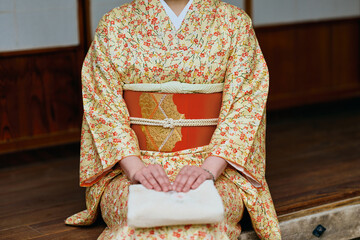 縁側で静かに佇む着物姿の女性