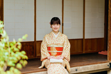 縁側で静かに佇む着物姿の女性