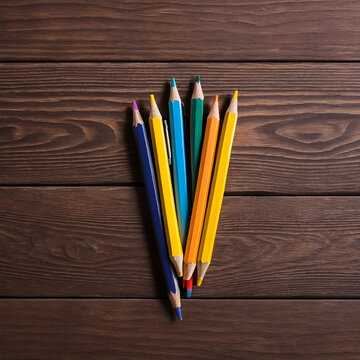 colored pensils on a brown table. drawind on a wooden background